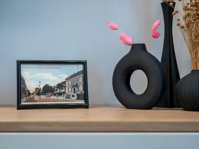 a black vase sitting on a shelf next to a picture at Stylish New High-End 3BR Apt on Vitoshka Blvd in Sofia