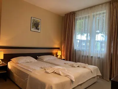 a hotel room with two beds and a window at Частен апартамент Банско in Bansko