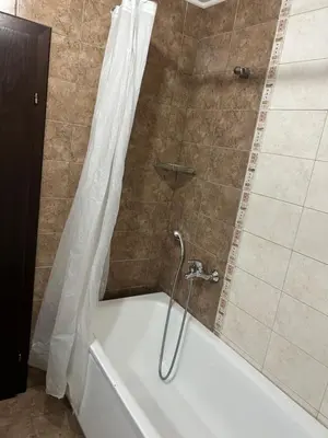 a shower with a tub with a shower curtain at Частен апартамент Банско in Bansko