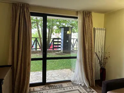a sliding glass door with a view of a yard at Частен апартамент Банско in Bansko