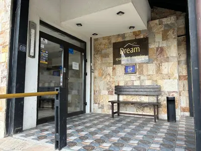 a bench sitting outside of a restaurant with a door at Частен апартамент Банско in Bansko