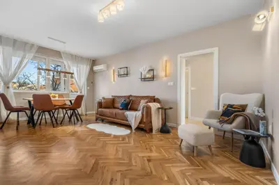 a living room with a couch and chairs and a table at Kapana - a 106m2 Flat right on the Pedestrian Street in Plovdiv
