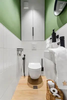 a bathroom with a toilet and a green wall at Kapana - a 106m2 Flat right on the Pedestrian Street in Plovdiv
