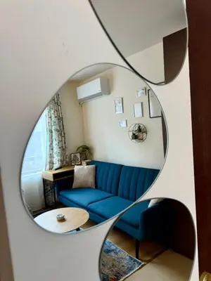 a living room with a blue couch and a mirror at Panorama Studio Home2Host in Bansko