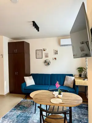 a living room with a blue couch and a table at Panorama Studio Home2Host in Bansko