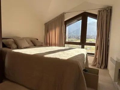 a bedroom with a bed and a large window at Golf view in Razlog