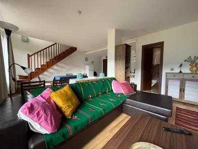 a living room with a green couch with colorful pillows at Golf view in Razlog