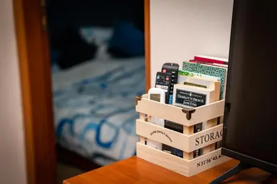 a stack of books on a table next to a bed at Bansko Peak Apartments 106 in Bansko