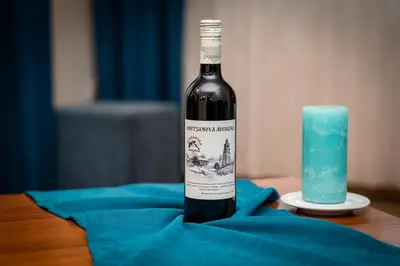a bottle of wine sitting next to a blue candle at Bansko Peak Apartments 106 in Bansko