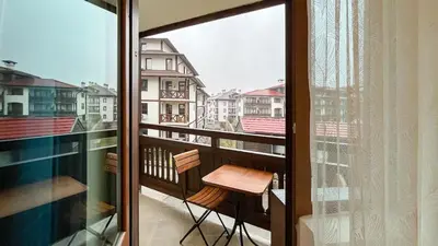 a balcony with a chair and a view of a city at Bansko Peak Apartments 106 in Bansko