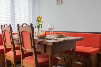a dining room table with two chairs and a table with wine glasses at Апартамент в центъра на Хисаря in Hisarya