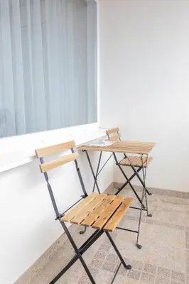 a desk and a wooden chair next to a window at Апартамент в центъра на Хисаря in Hisarya