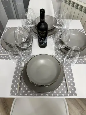 a table with a plate and wine glasses on it at Flora Residence Cozy Apartments in Borovets