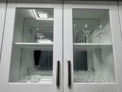 a white cabinet filled with wine glasses at Flora Residence Cozy Apartments in Borovets