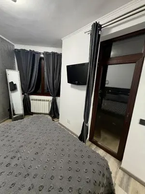 a bedroom with a bed and a flat screen tv at Flora Residence Cozy Apartments in Borovets