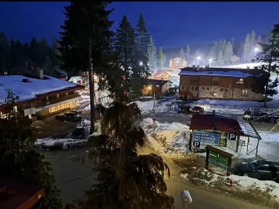 a snow covered town at night with snow covered buildings at Flora Residence Cozy Apartments in Borovets