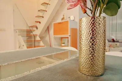 a gold vase with a flower on a table at GOLF Queen MARIA Apartment Home2Host in Razlog