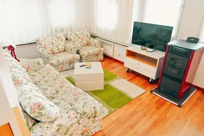 a living room with a couch and a tv at GOLF Queen MARIA Apartment Home2Host in Razlog