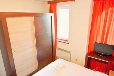 a bedroom with a large closet and a television at GOLF Queen MARIA Apartment Home2Host in Razlog