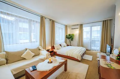 a hotel room with a bed and a couch and a living room at Bansko Peak Apartments 304 in Bansko