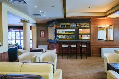 a waiting room with white chairs and a bar at Bansko Peak Apartments 304 in Bansko