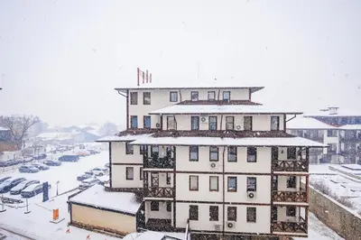 a large building in the snow with a parking lot at Bansko Peak Apartments 304 in Bansko