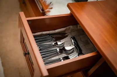 a drawer in a wooden cabinet filled with utensils at Bansko Peak Apartments 304 in Bansko