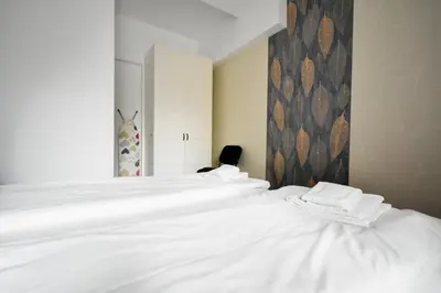 a white bed in a bedroom with a wall at Cozy Central 1BD Apartment in Sofia
