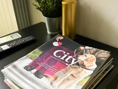a magazine sitting on a desk with a dog on it at Cozy Central 1BD Apartment in Sofia