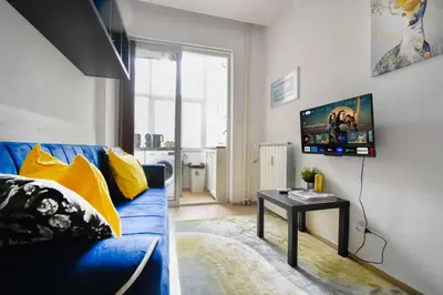 a living room with a blue couch and a table at Cozy Central 1BD Apartment in Sofia