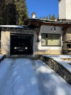 a garage with snow on the ground in front of a house at Къща за гости Пампорово в махала Кочорите in Pamporovo