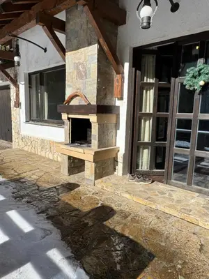 a stone oven on the side of a house at Къща за гости Пампорово в махала Кочорите in Pamporovo
