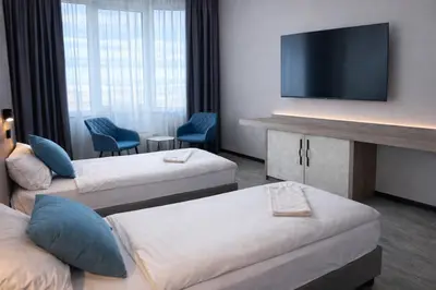 a hotel room with two beds and a flat screen tv at Vital Hotel in Sofia