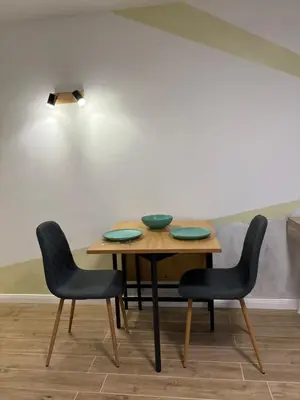 a table with two chairs and a light on top at Парксайд Лейн Студио in Bansko