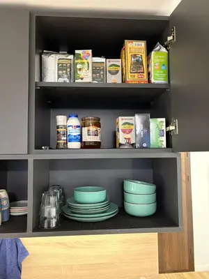 a pantry with bowls and plates on a shelf at Парксайд Лейн Студио in Bansko