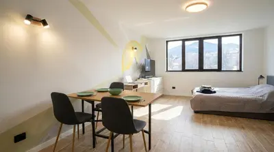 a room with a table and chairs and a bed at Парксайд Лейн Студио in Bansko