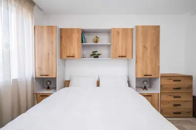 a bedroom with a large bed and wooden cabinets at Sunny & Modern 1BR Apartment in Sofia