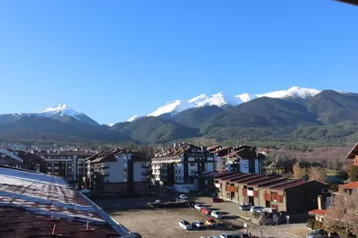 a city with snow capped mountains in the background at Bansko Peak Apartments 508 in Bansko