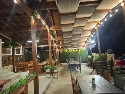 a restaurant with wooden ceilings and tables and chairs at Свети Георги in Tsigov Chark