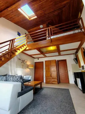 a living room with a white couch and a loft at къща за гости Цветелина и Митко in Bansko