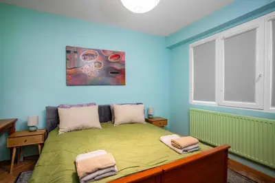 a bedroom with a green bed and a window at Life in Colours - Artistic 1BD Apartment in Sofia