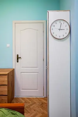 a clock on the wall next to a white door at Life in Colours - Artistic 1BD Apartment in Sofia