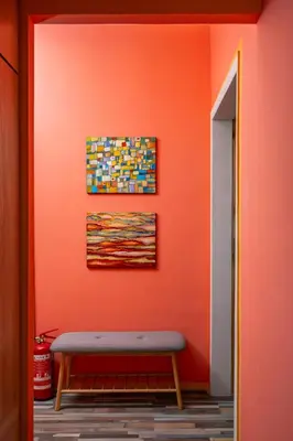 a bench in a room with an orange wall at Life in Colours - Artistic 1BD Apartment in Sofia