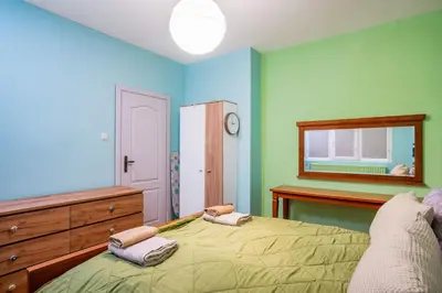 a bedroom with a bed and a dresser and a mirror at Life in Colours - Artistic 1BD Apartment in Sofia