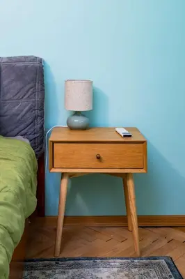 a nightstand with a lamp on it next to a bed at Life in Colours - Artistic 1BD Apartment in Sofia