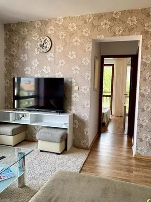 a living room with a flat screen tv on the wall at Yeti Complex in Bansko