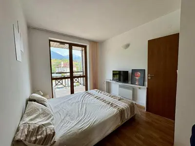 a bedroom with a bed and a large window at Yeti Complex in Bansko