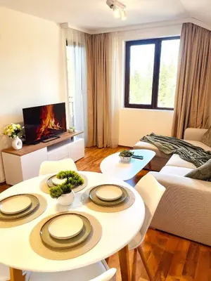 a living room with two tables and a fireplace at Pamporovo Cozy Ski-Close Nest in Pamporovo
