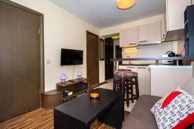 a small living room with a couch and a kitchen at Private Ap in Perun Lodge Ski Escape & Spa in Bansko