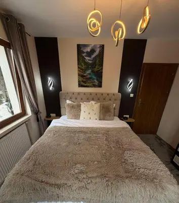 a bedroom with a large bed with lights on the wall at Elizi2 winter apartments Pamporovo in Pamporovo